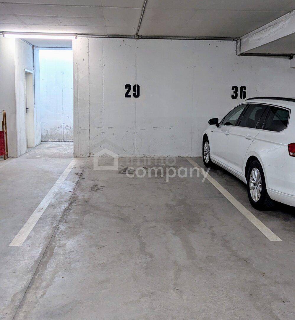 Tiefgarage mit markierten Stellplätzen und einem geparkten Fahrzeug, bietet sichere Parkmöglichkeiten.