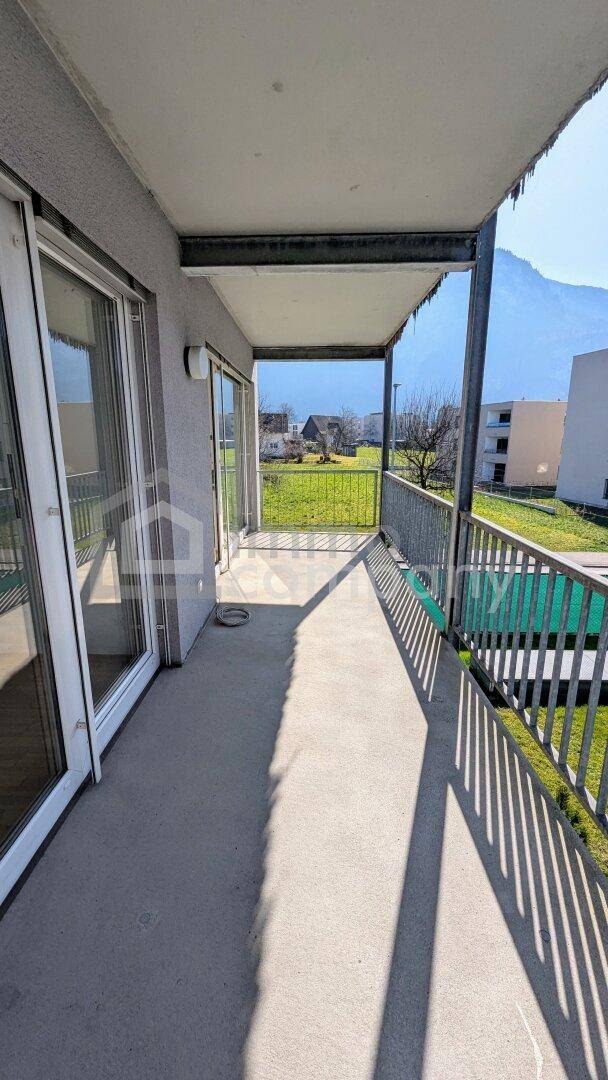 Geräumiger, leerer Balkon mit weitem Blick auf die umliegende Landschaft und die majestätischen Berge.