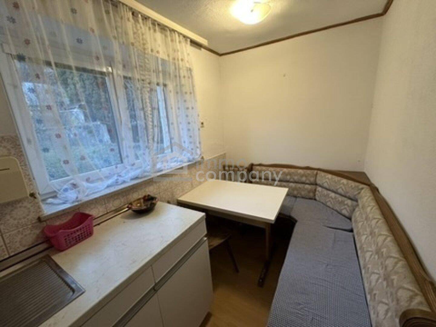 Kleine Küche mit Essbereich und Fensterblick ins Grüne, ideal für gemütliche Mahlzeiten.