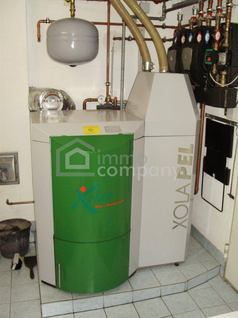 Funktionaler Heizraum mit moderner Pelletheizung und sichtbaren Installationen.