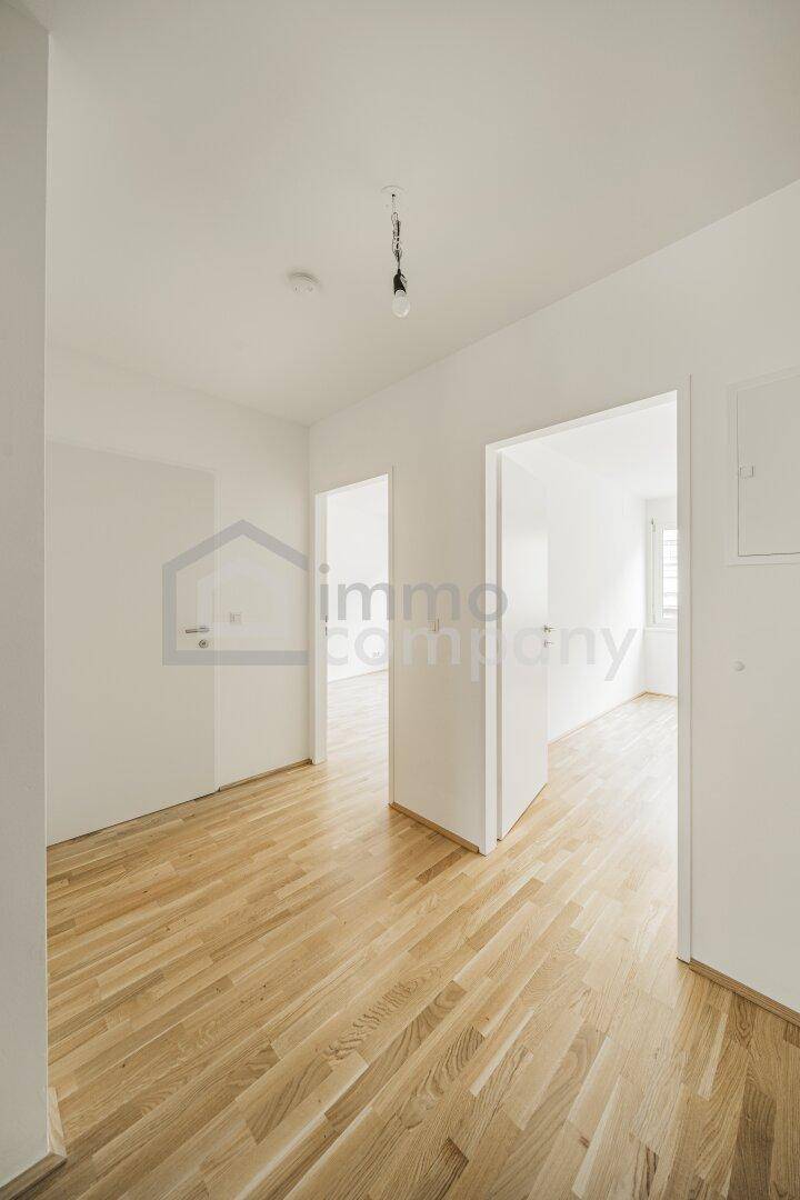 Heller Flur mit Eichenparkettboden und Zugang zu verschiedenen Räumen in der Wohnung.