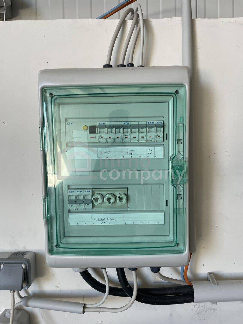 Nahaufnahme eines elektrischen Verteilerkastens oder Sicherungskastens an einer weißen Wand montiert.