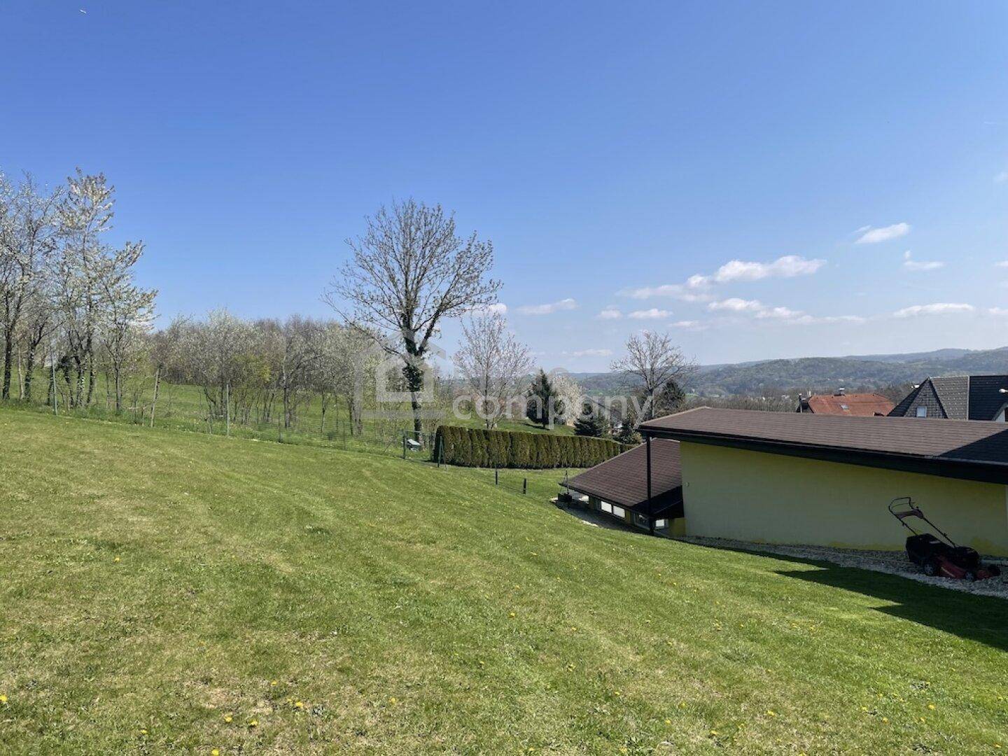 Großer, gepflegter Rasenbereich mit Bäumen und weitem Blick in die Landschaft.