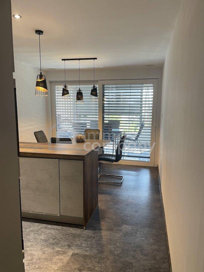 Essbereich mit modernem Tisch und Stühlen, direktem Zugang zur Terrasse.