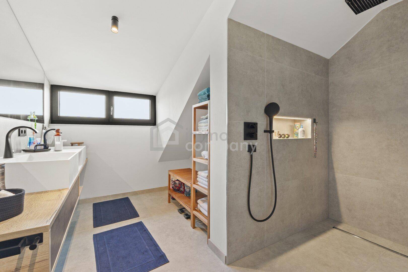 Modernes Badezimmer mit begehbarer Dusche, Einzelwaschbecken und Fenster unter Dachschräge.