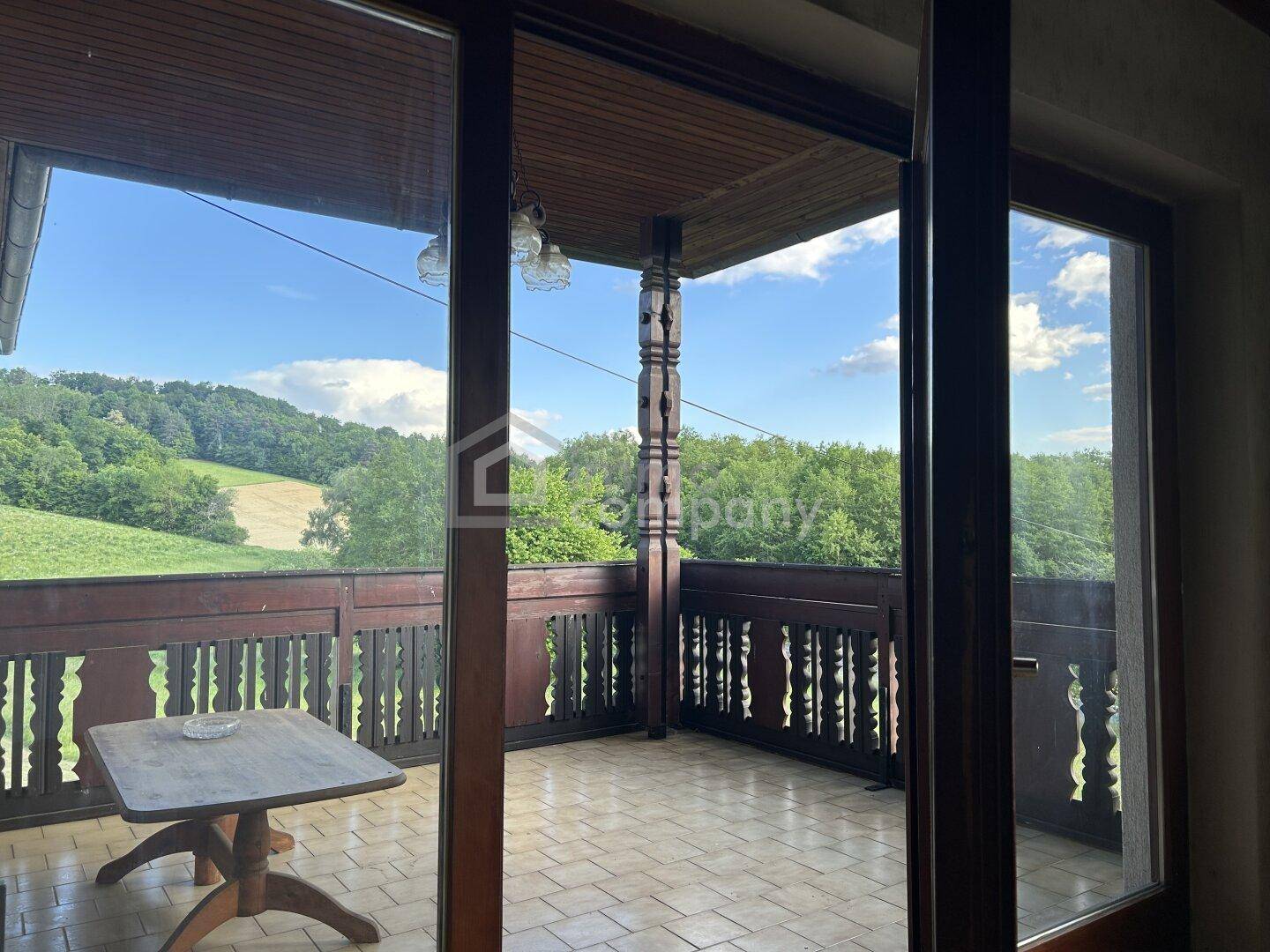 Innenansicht mit Zugang zu einem Balkon, der einen weiten Blick über die Landschaft bietet.