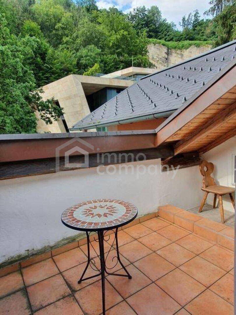 Gemütliche Terrasse mit Terrakottafliesen, einem Mosaiktisch und Blick auf die umliegende Landschaft.