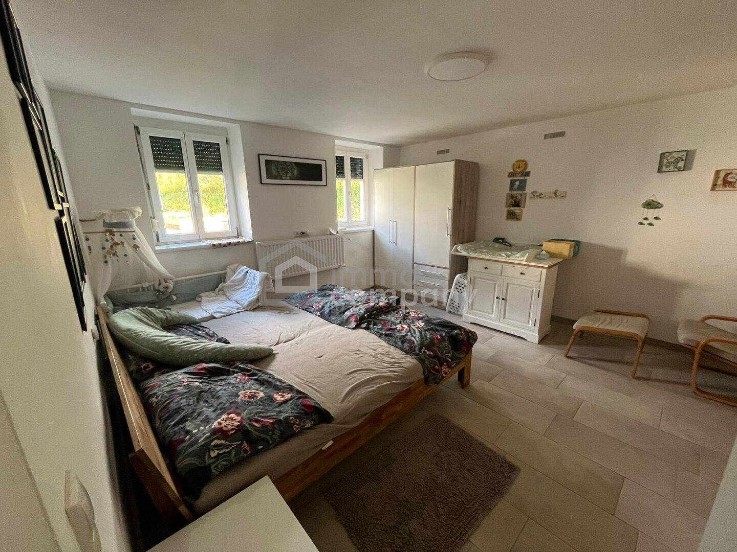 Gemütliches Schlafzimmer mit zwei Betten, Kleiderschrank und Fenstern mit Rollläden.
