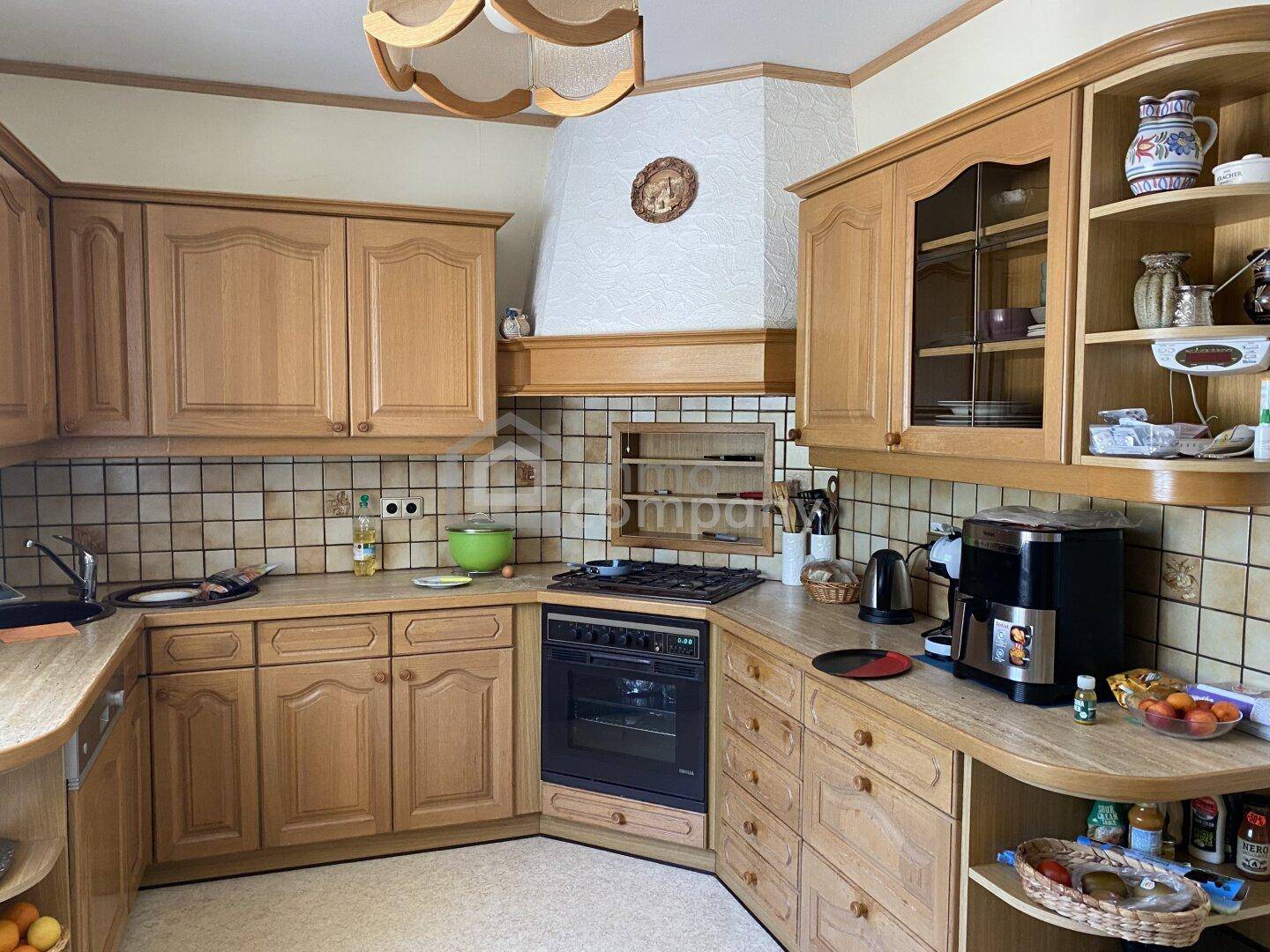 Traditionelle Holzküche mit Gasherd, Fliesenrückwand und viel Stauraum.