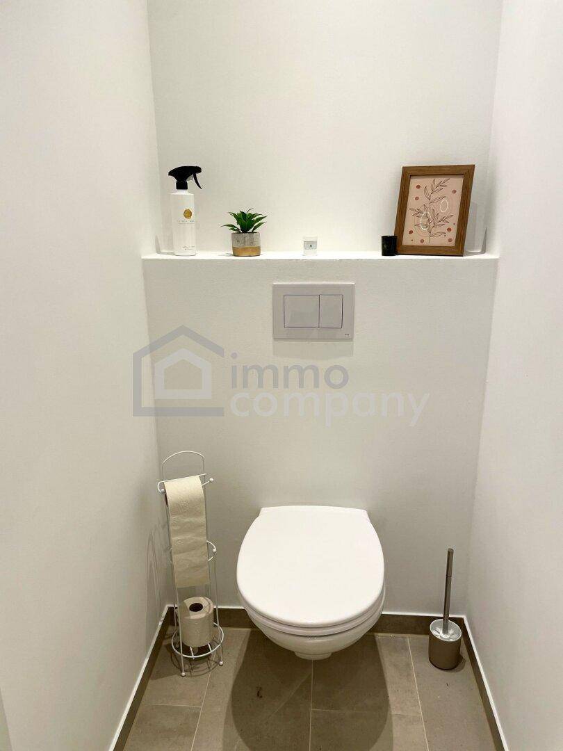 Kleines Gäste-WC mit wandhängender Toilette und minimalistischer Einrichtung.
