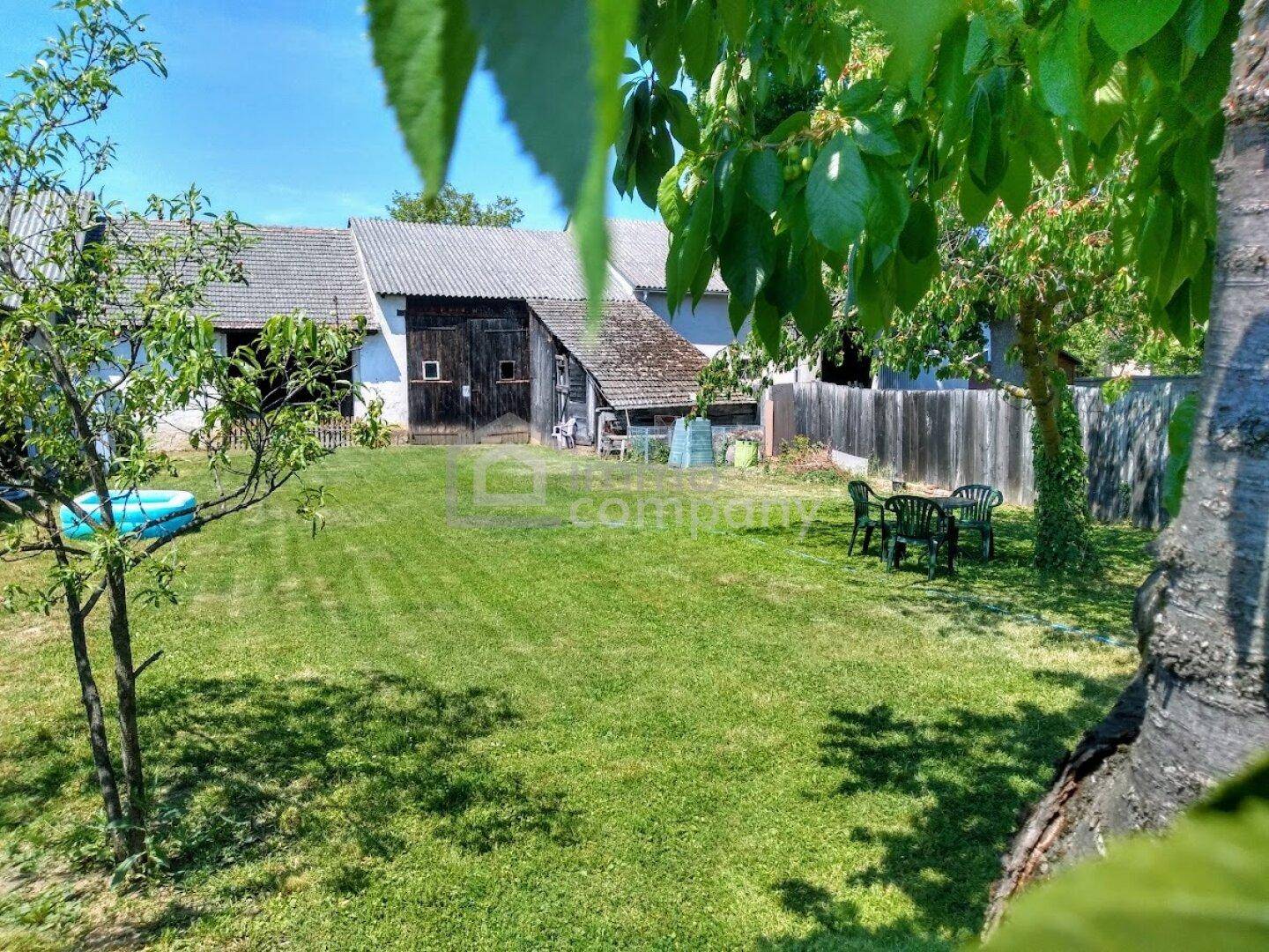 Großer Garten mit Rasenfläche, kleinem Pool und Sitzgelegenheiten im Freien hinter dem Haus.