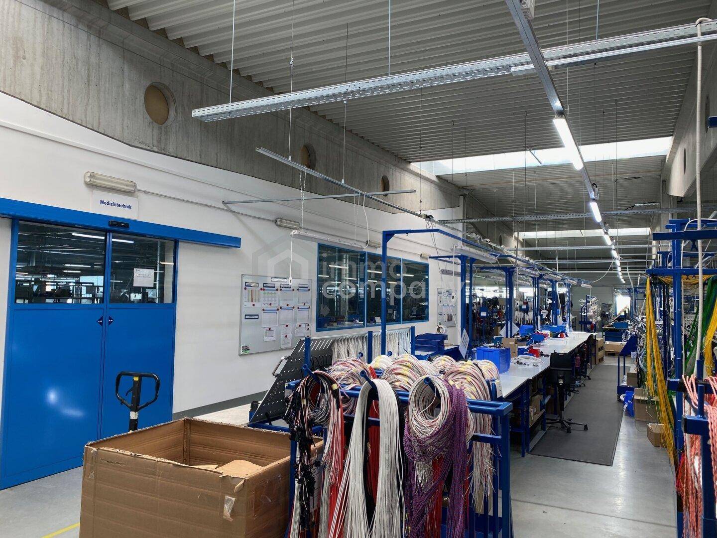 Produktionsbereich mit Zugang zu einem Büro und weiteren Arbeitsstationen.