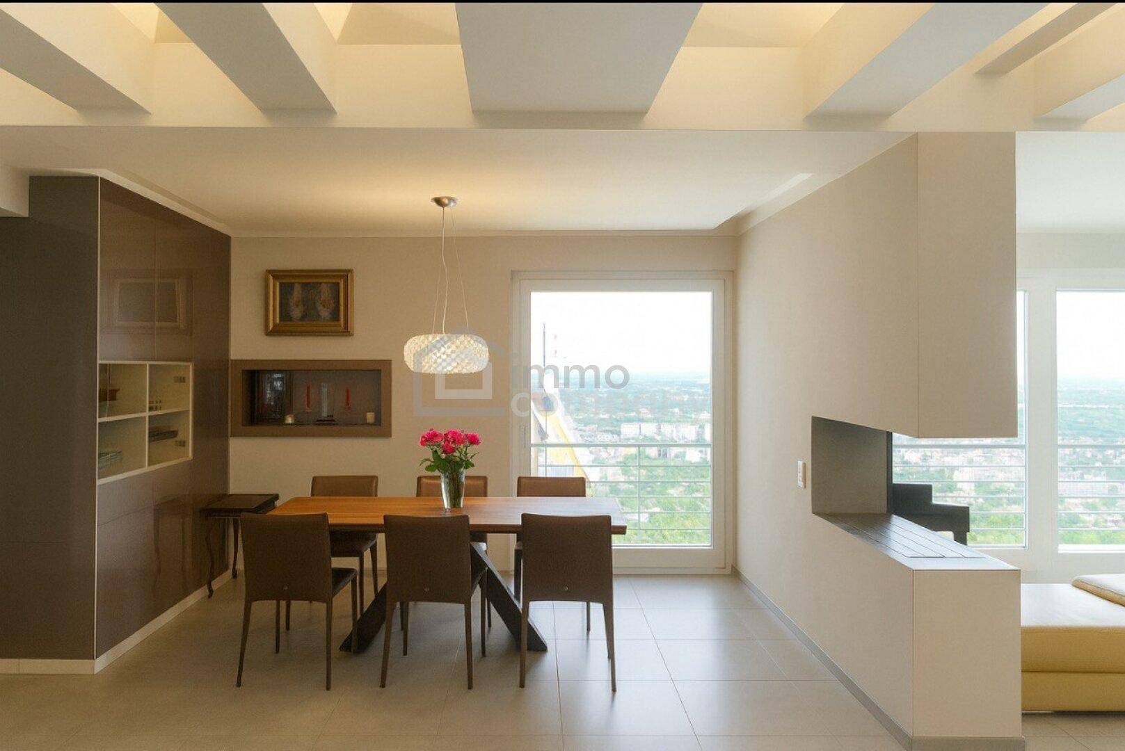 Eleganter Essbereich mit Holztisch, modernen Stühlen und Blick auf die Stadt.