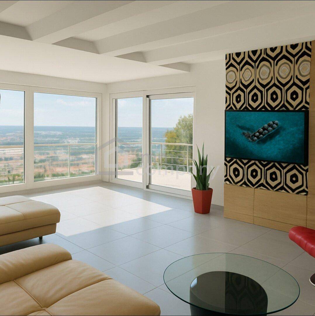 Lichtdurchflutetes Wohnzimmer mit Panoramafenstern und weitem Ausblick über die Landschaft.