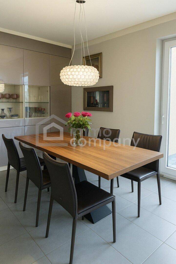 Detailansicht des Essbereichs mit Holztisch, schwarzen Stühlen und moderner Hängelampe.