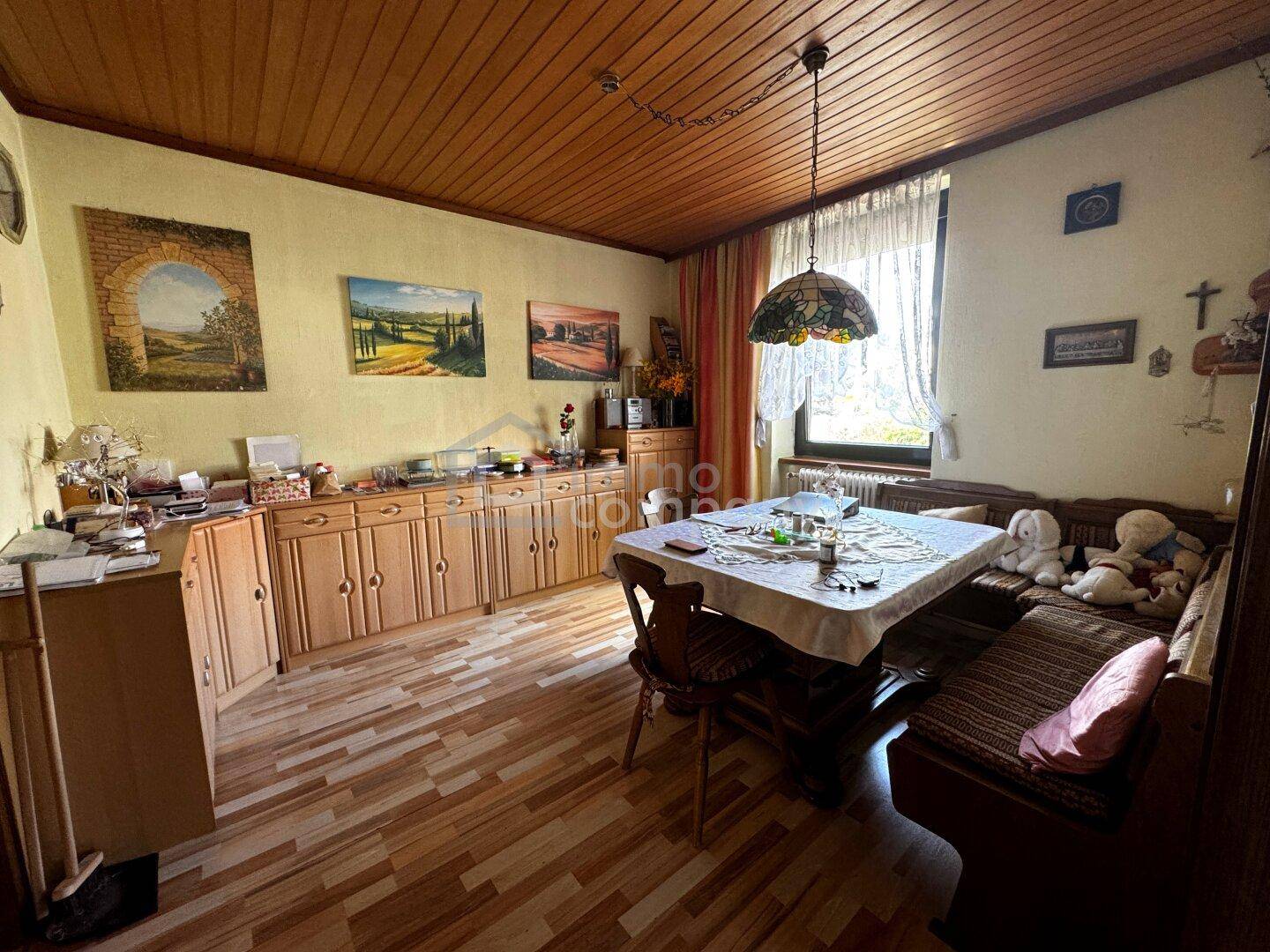Gemütlicher Essbereich mit Holztäfelung an der Decke, traditionellen Möbeln und Parkettboden.
