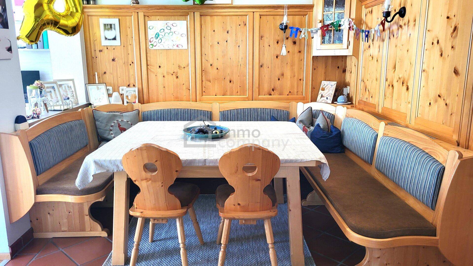 Gemütlicher Essbereich im Landhausstil mit Holzbänken, Esstisch und Holzvertäfelung.