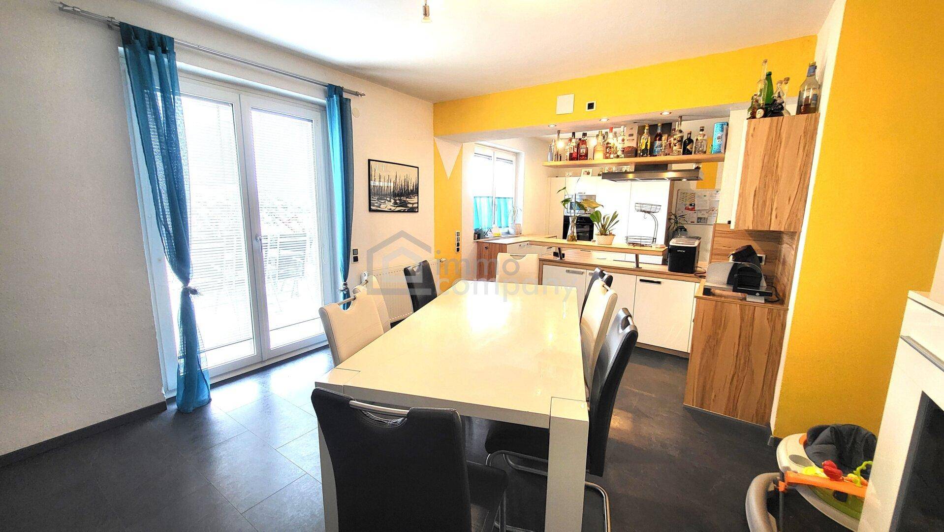Geräumiger Wohn-Essbereich mit Zugang zur Terrasse und moderner offener Küche.
