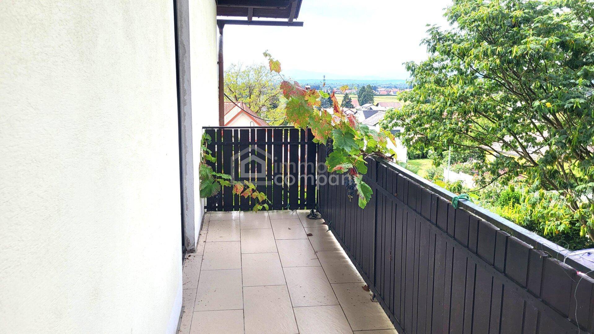 Kleiner Balkon mit Fliesenboden und weitem Blick über die umliegende Landschaft.