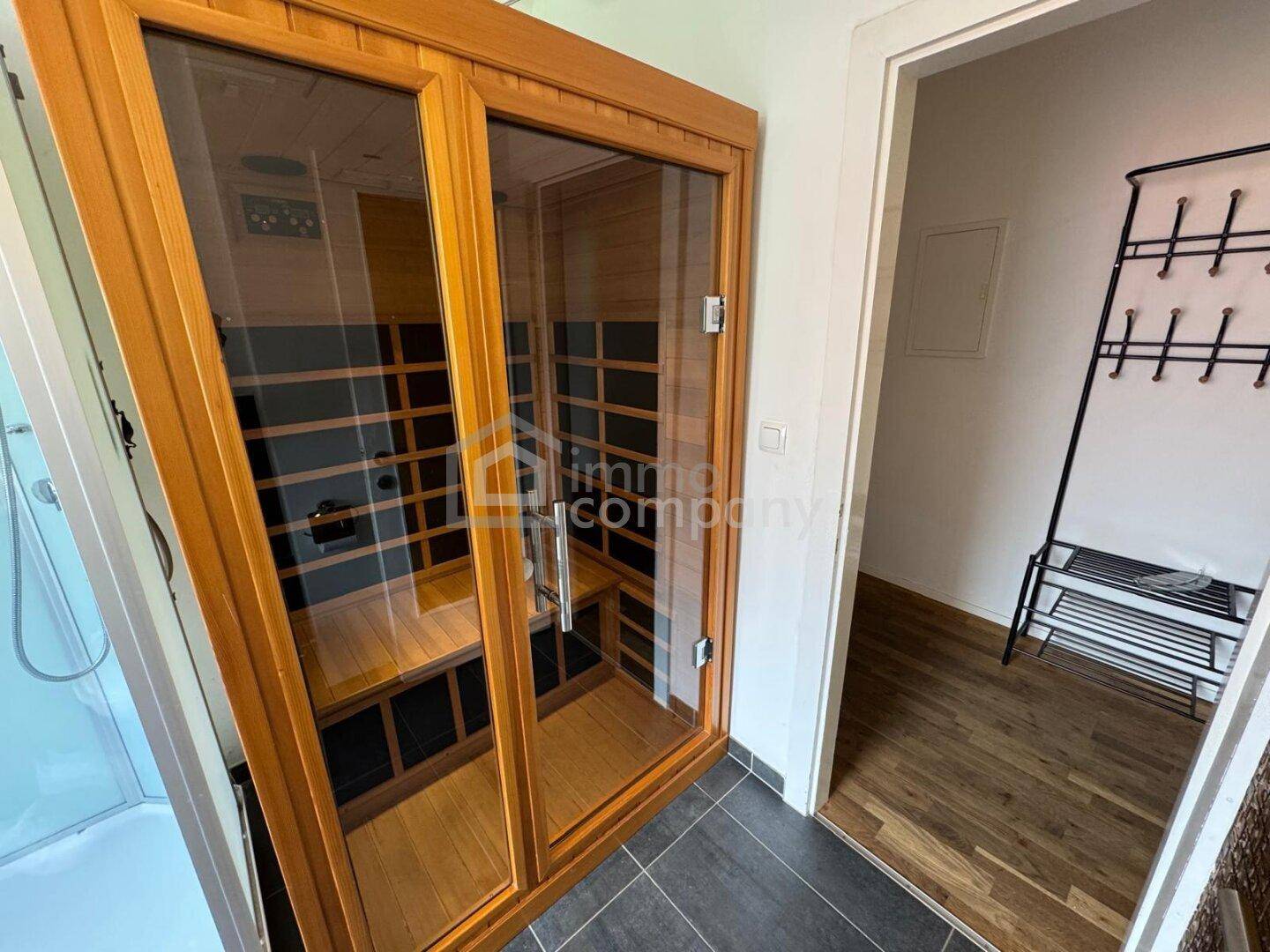 Moderne Infrarotsauna mit Holzelementen und Glasfront.