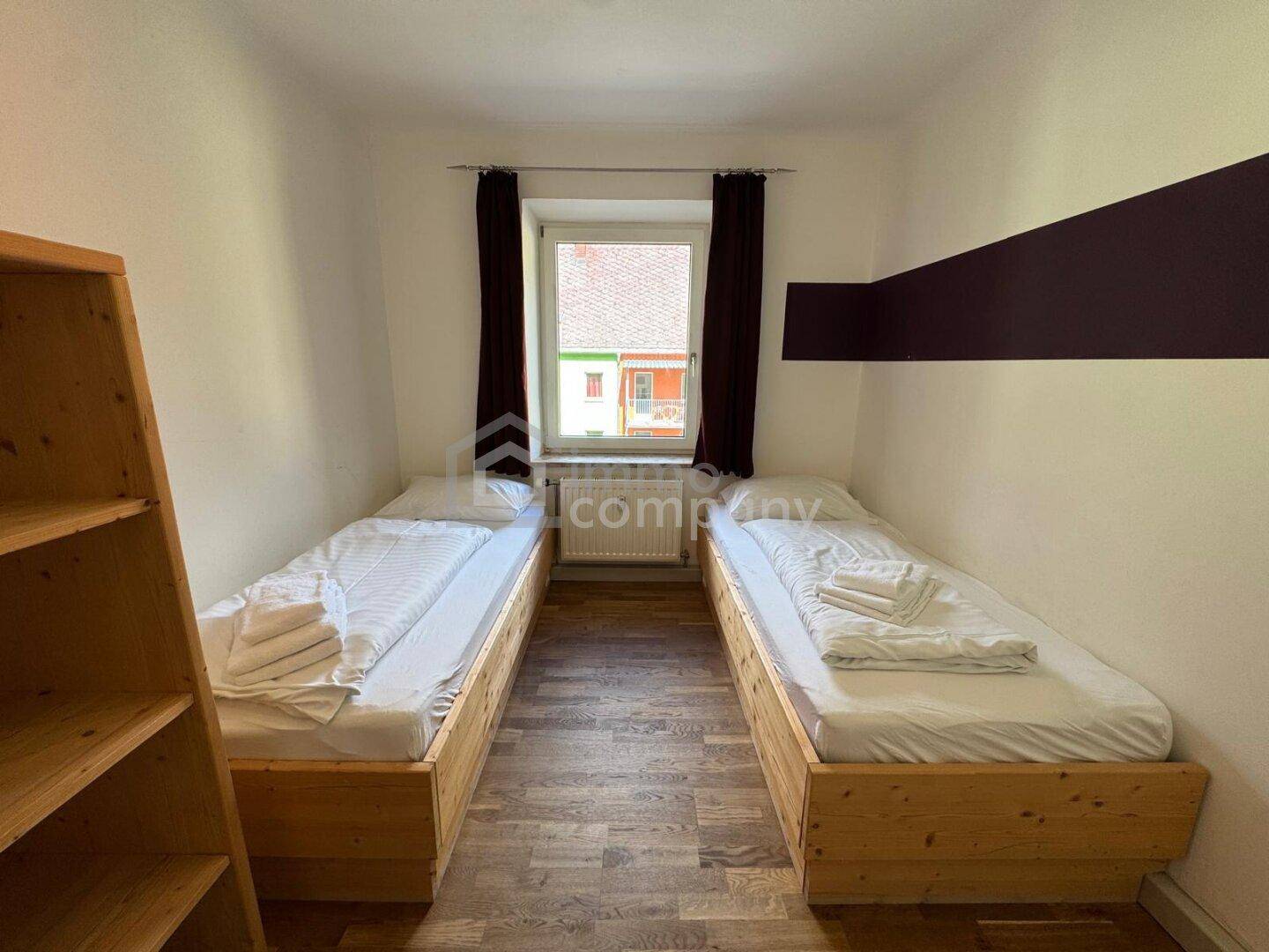 Gemütliches Schlafzimmer mit zwei Einzelbetten und Holzboden.