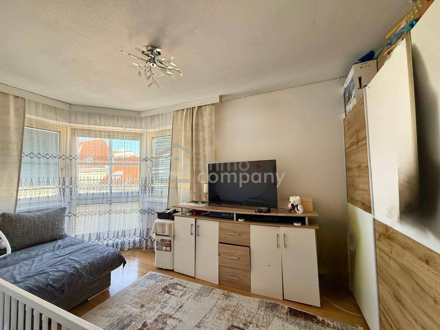 Heller Wohnraum mit Erkerfenster, TV-Möbel und Stauraum.