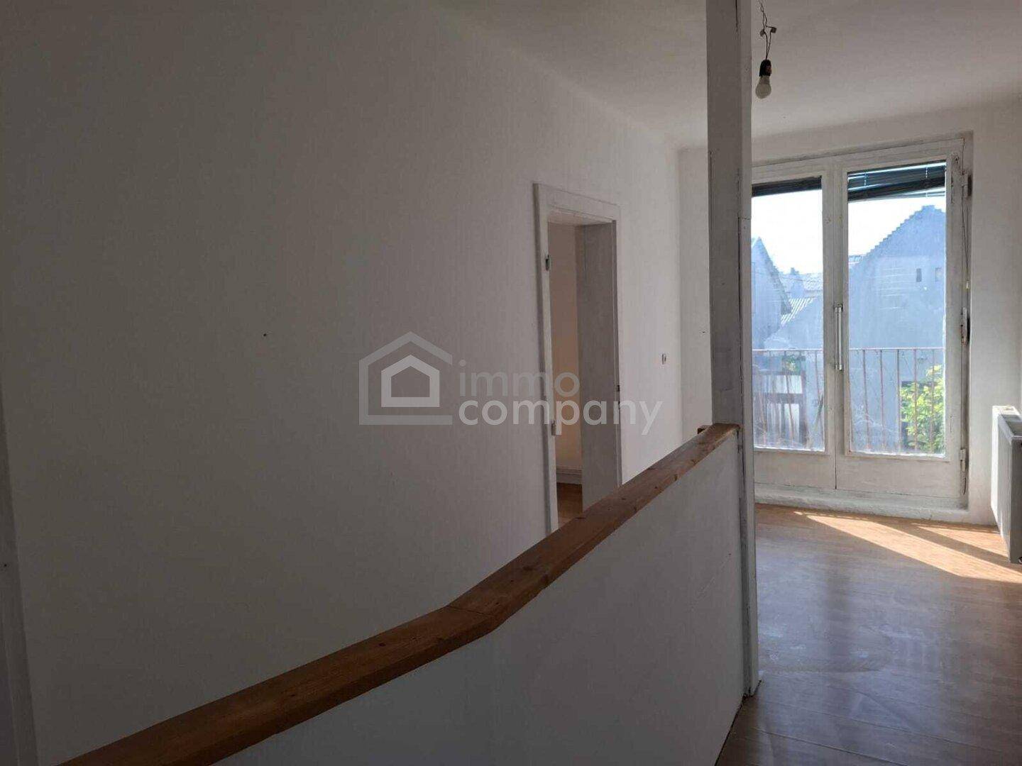 Flur oder Treppenabsatz mit Laminatboden und Zugang zu einem französischen Balkon.
