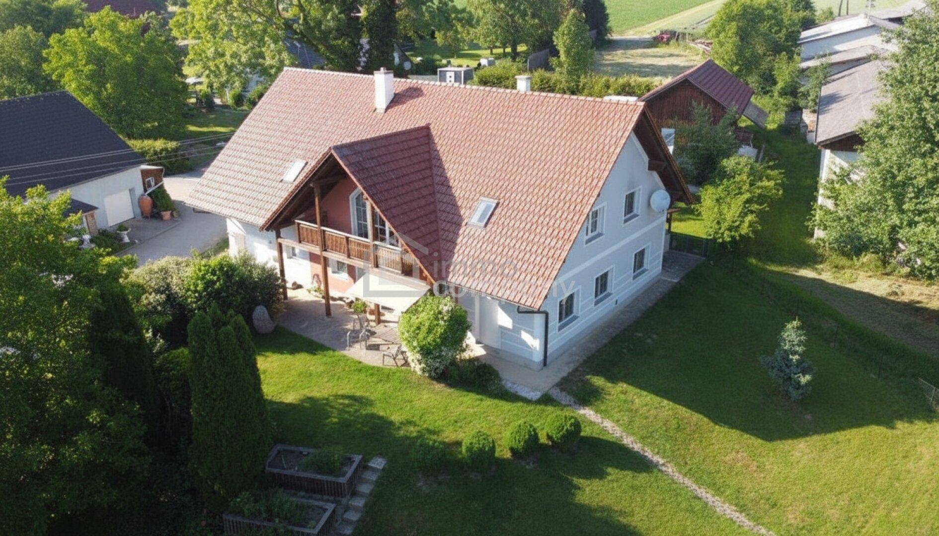 Luftaufnahme des Landhauses mit weitläufigem Garten und angrenzenden Feldern.