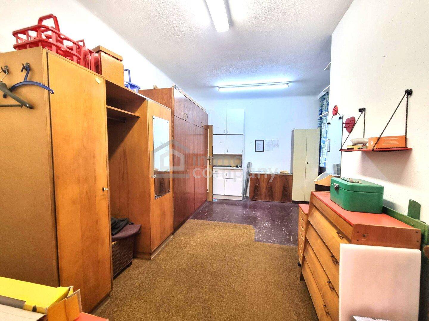 Schlafzimmer mit älteren Holzschränken und Teppichboden, auch als Stauraum genutzt.
