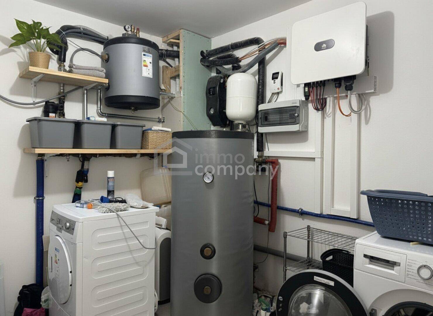 Funktionaler Hauswirtschaftsraum mit Waschmaschinen, Warmwasserspeicher und Heizungsinstallationen.