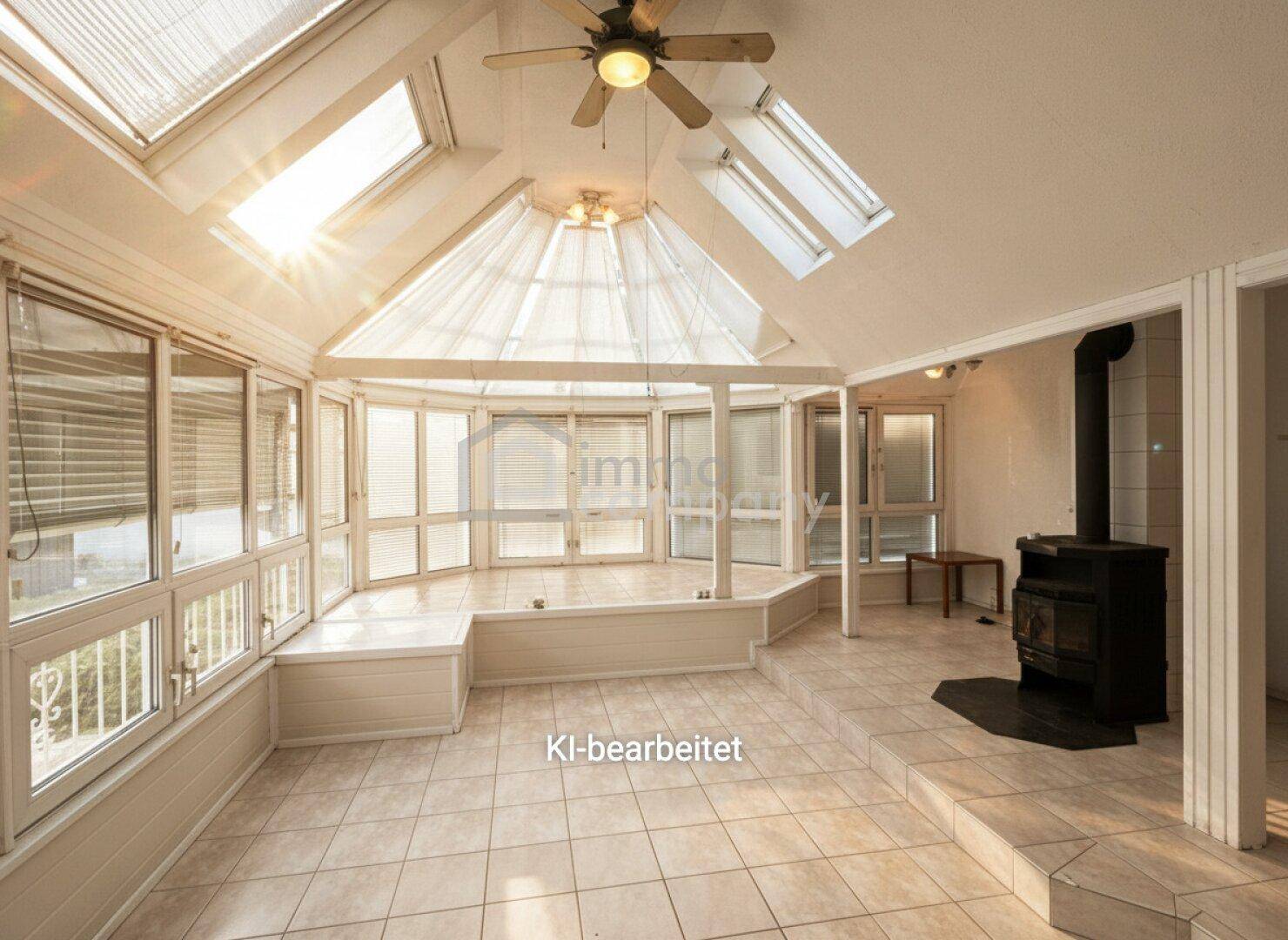 Heller Wintergarten mit vielen Fenstern, Dachfenstern, Fliesenboden und einem gemütlichen Holzofen.
