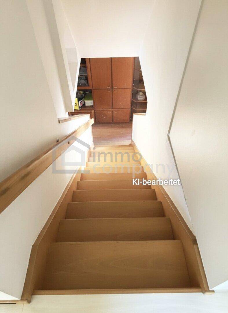 Helle Holztreppe mit Geländer, die verschiedene Ebenen des Hauses miteinander verbindet.