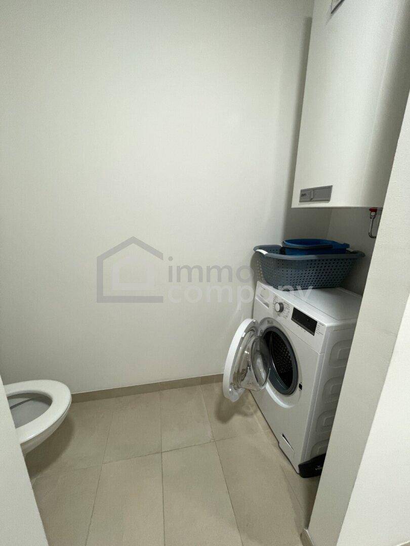 Praktischer Waschraum mit Toilette und Waschmaschine, ideal für den täglichen Gebrauch.