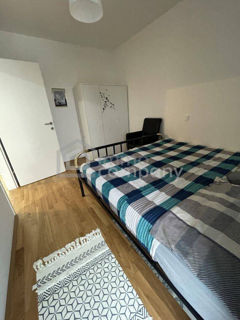 Helles Schlafzimmer mit Holzfußboden und einem geräumigen Kleiderschrank.