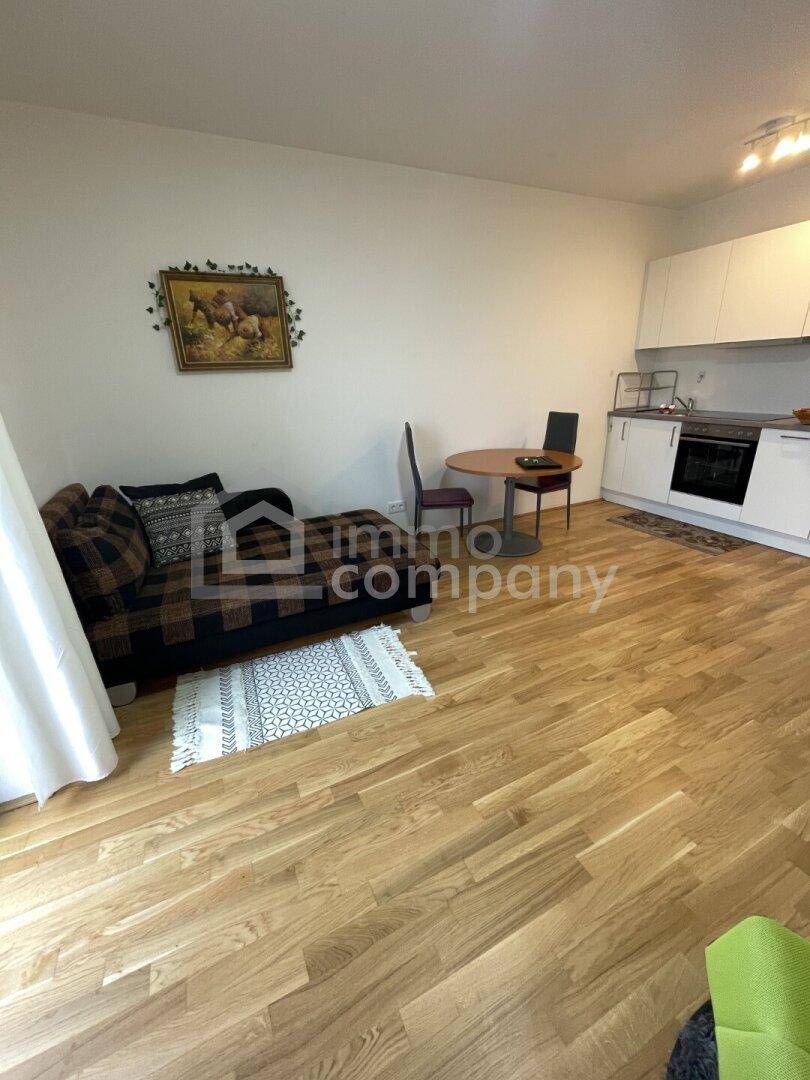 Offener Wohnbereich mit Essgelegenheit und integrierter Küche, ausgestattet mit Holzfußboden.