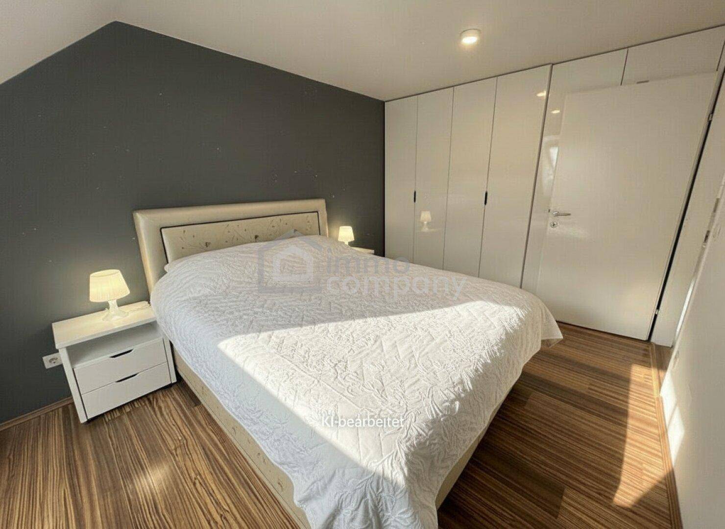 Helles Schlafzimmer mit Holzboden, Einbauschränken und schräger Decke im Dachgeschoss.