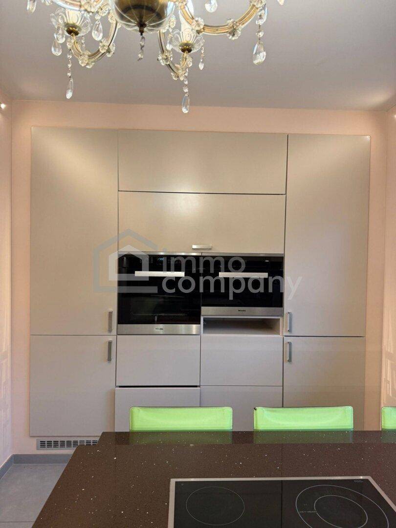 Moderne Einbauküche mit integrierten Miele-Geräten und Induktionskochfeld.