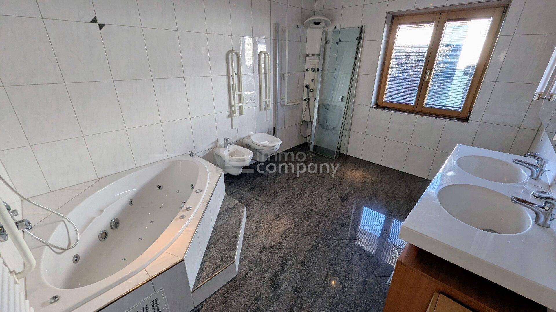 Großes Badezimmer mit Whirlpool-Badewanne, Doppelwaschbecken, Bidet und Dusche.