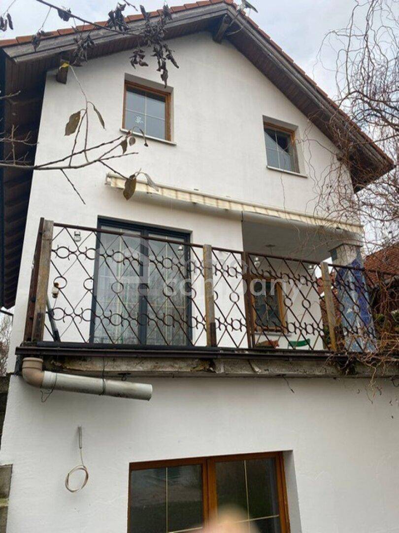 Balkon mit schmiedeeisernem Geländer an der Fassade eines älteren Hauses, das Renovierung benötigt.