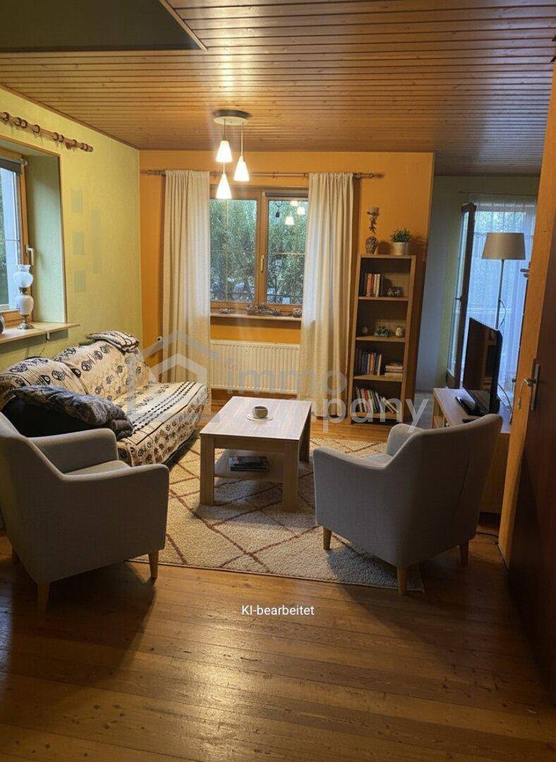 Wohnzimmer mit Holzboden, Holzdecke und orangefarbenen Wänden, eingerichtet mit bequemen Sofas.