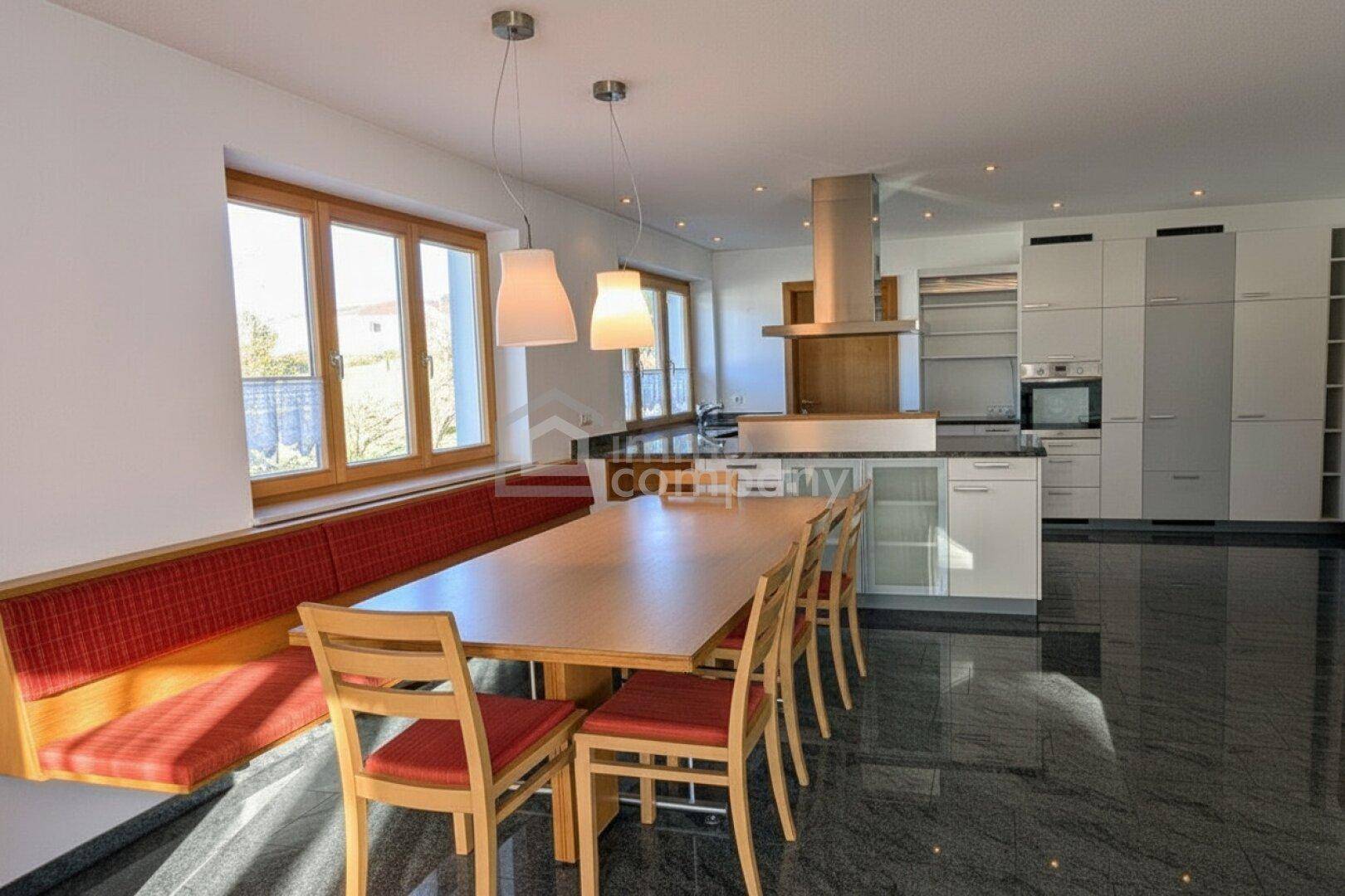 Moderne Küche mit Essbereich, dunklem Granitboden und großen Fenstern.