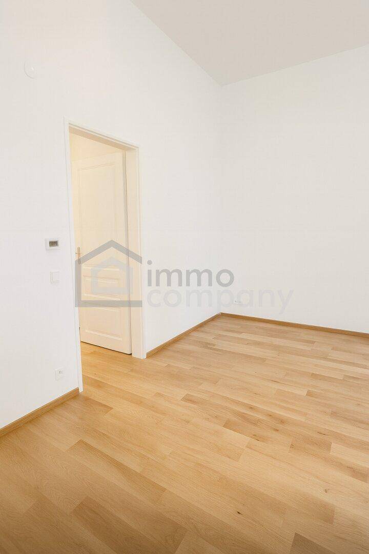 Leerer Raum mit hellem Holzboden und weiß gestrichenen Wänden, bereit für individuelle Gestaltung.