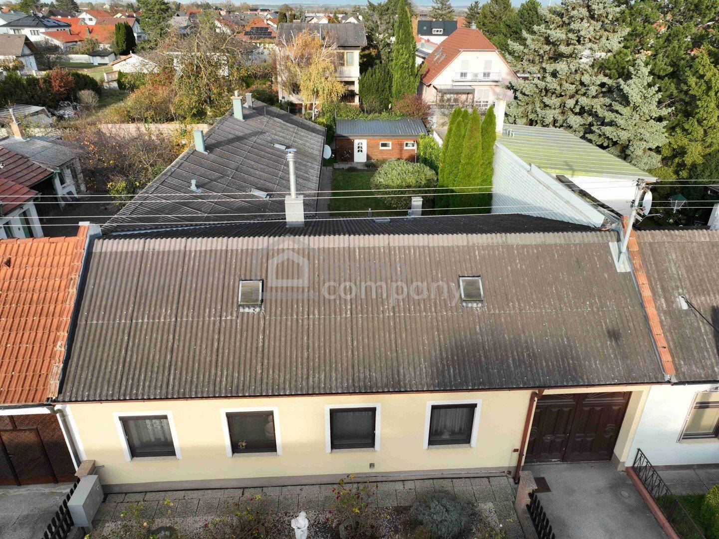 Luftaufnahme des Hauses mit Dach und umliegenden Gärten in einer Wohnsiedlung.