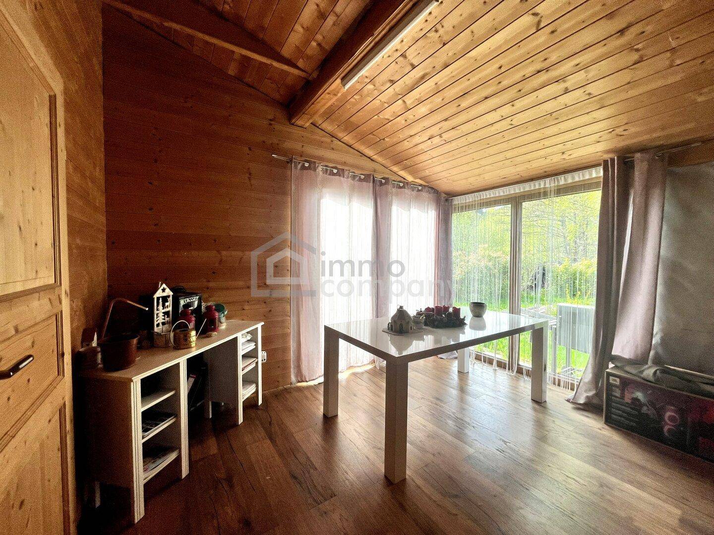 Heller Essbereich mit Holzboden und großen Fenstern, die viel Tageslicht hereinlassen.