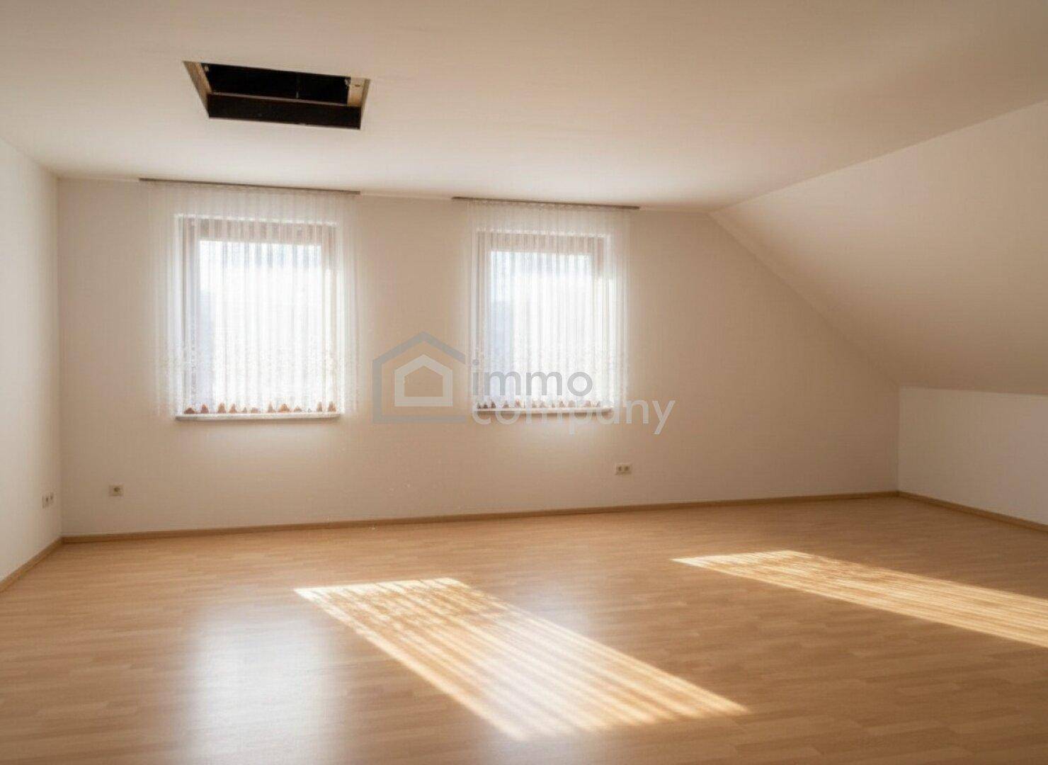 Geräumiger Dachbodenraum mit Holzboden und Fenstern, vielseitig nutzbar.
