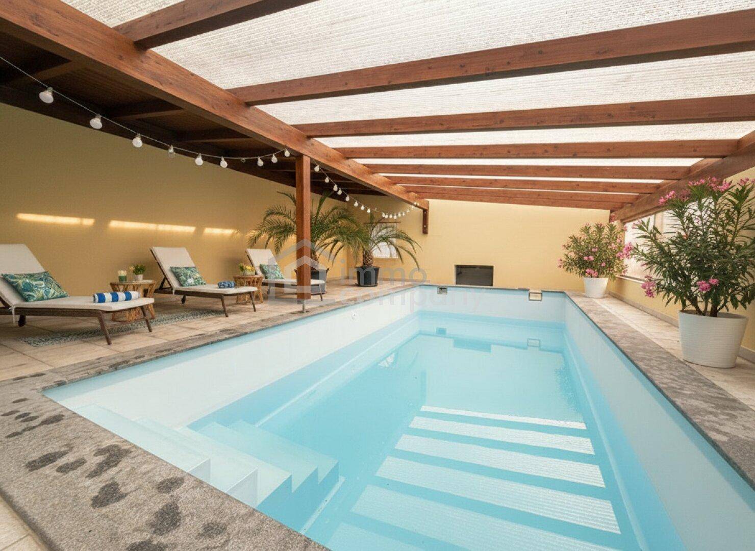 Überdachter Poolbereich mit Liegestühlen und Pflanzen, ideal zum Entspannen im Freien.