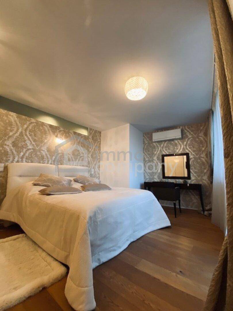 Gemütliches Schlafzimmer mit Holzboden, gemusterter Tapete und einem bequemen Doppelbett.