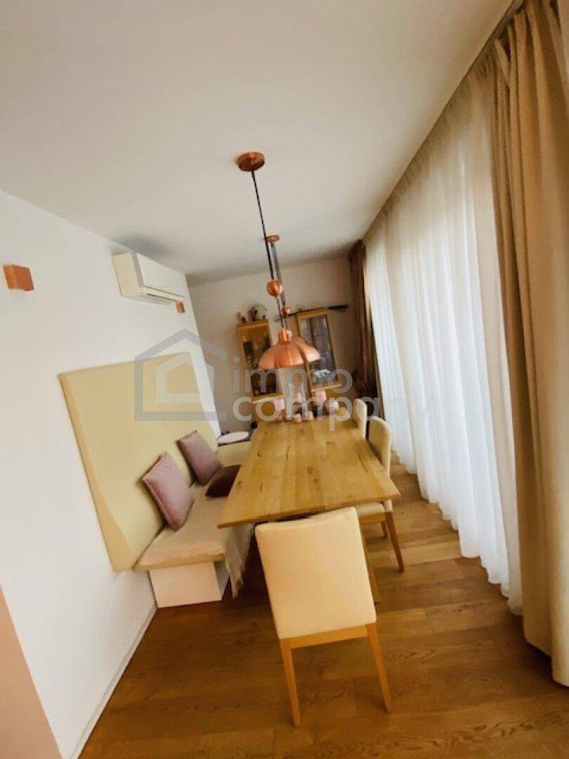 Heller Essbereich mit Holztisch, Sitzbank und großen Fenstern für viel Tageslicht.