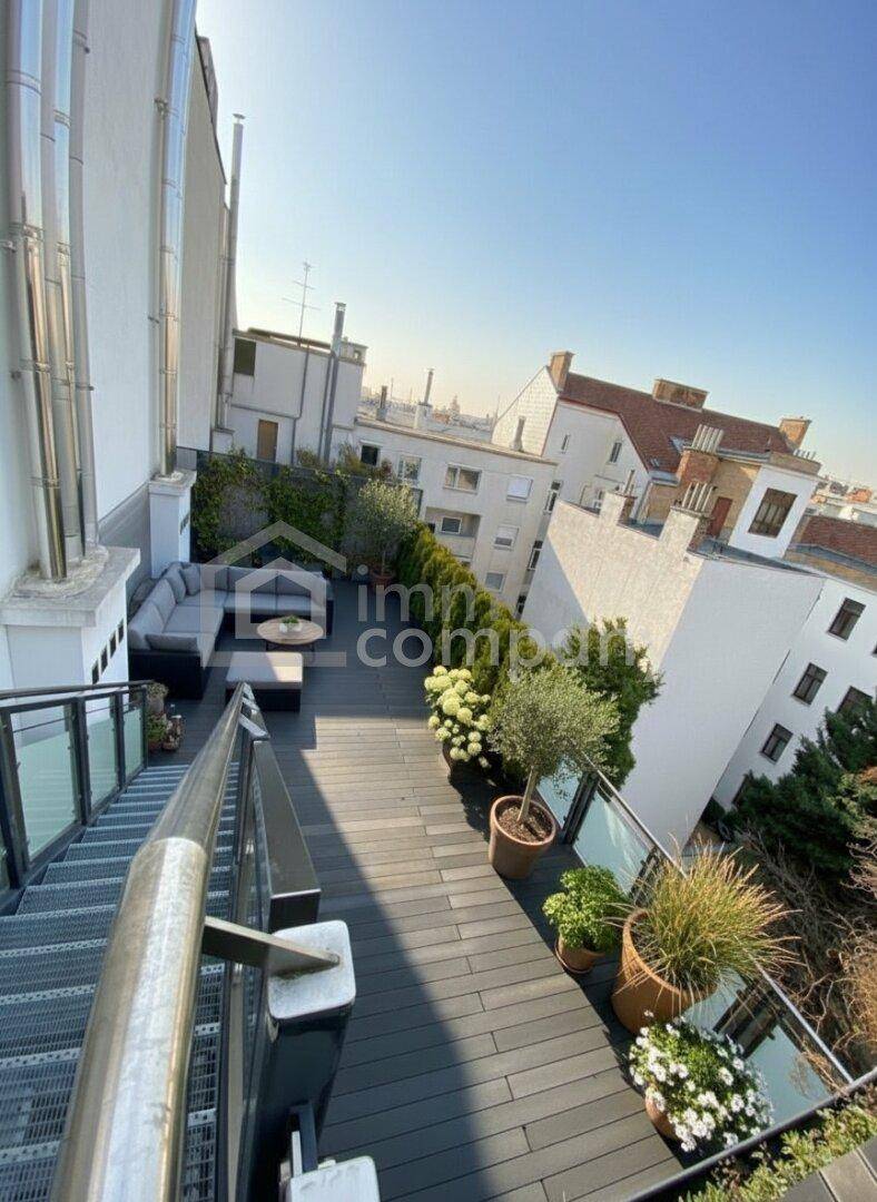 Großzügige Dachterrasse mit bequemen Sitzgelegenheiten, Pflanzen und Blick auf die Stadt.