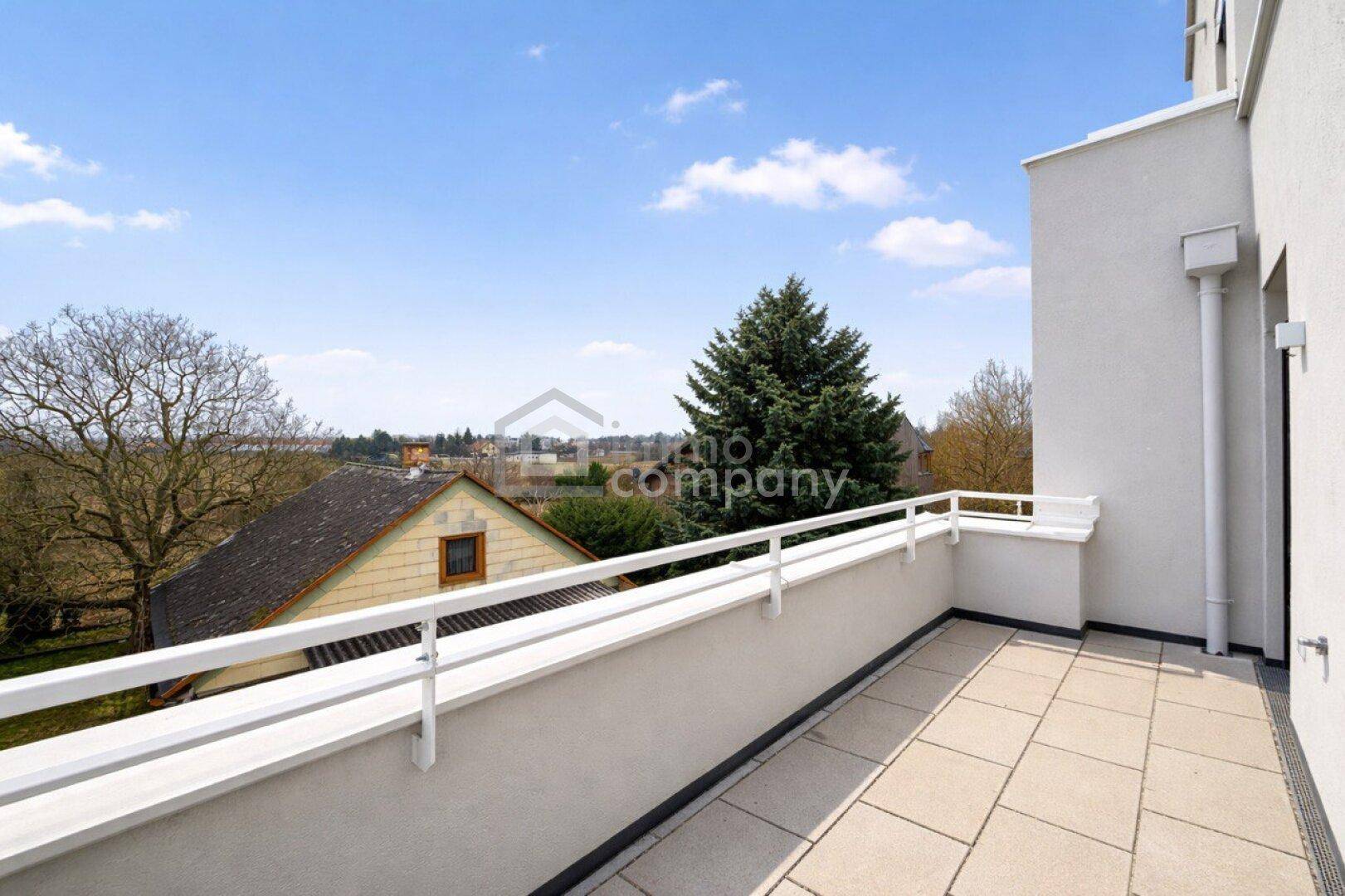 Geräumiger Balkon mit Fliesenboden und weitem Blick über die Umgebung.